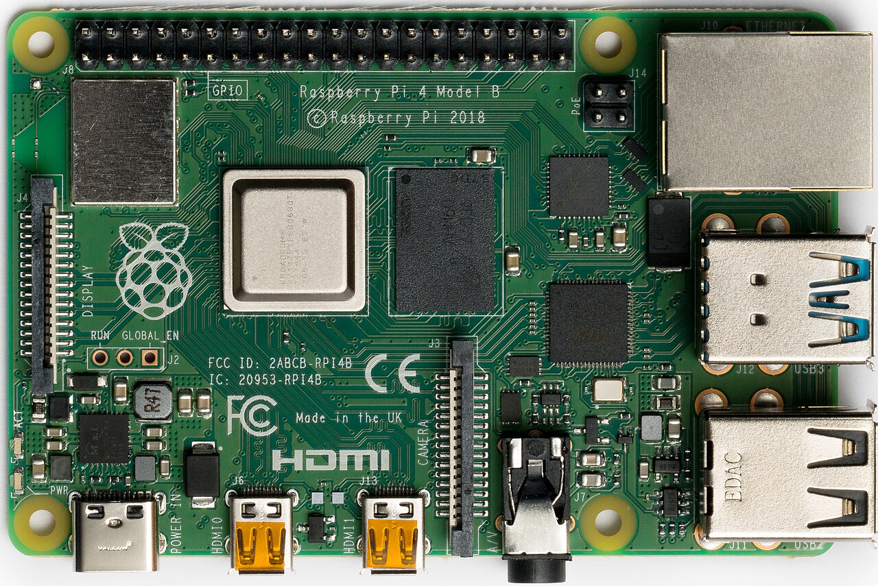 Actual Raspberry Pi 4 Model B photographed from above, with markers placed directly on the 40-pin header, USB-C socket, two micro-HDMI sockets, Ethernet jack, and four-pin PoE header